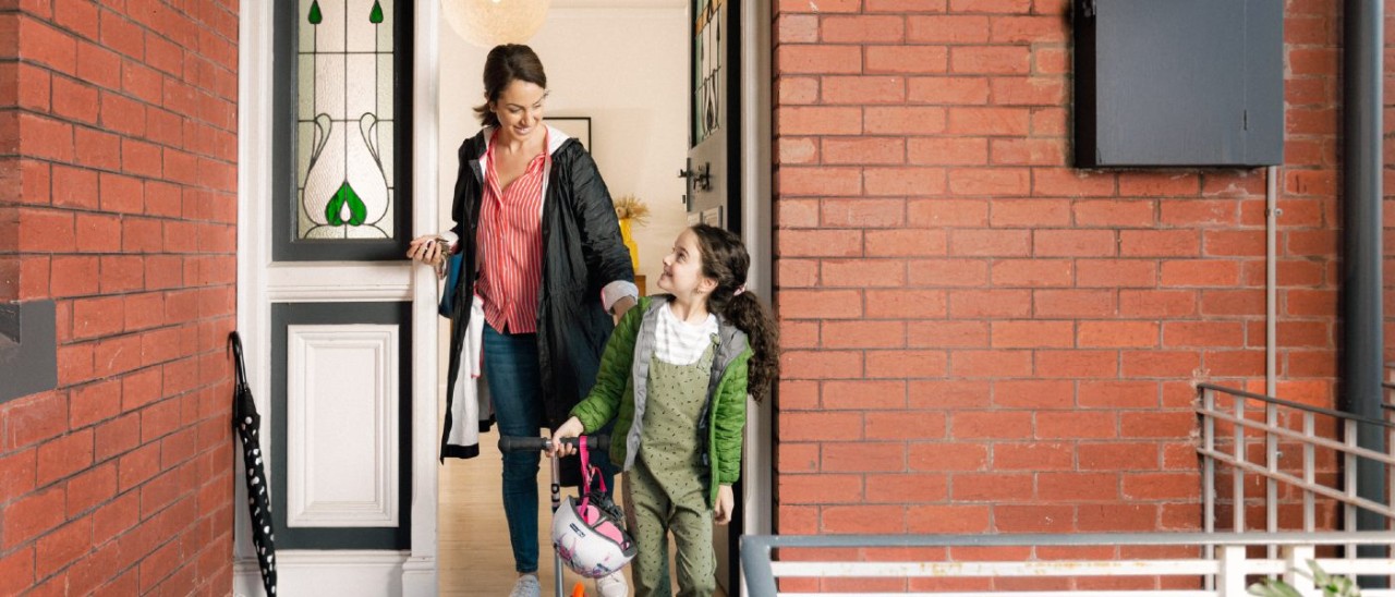 Family Living Property Home_RACV mother and daughter exiting their brick home in winter coats