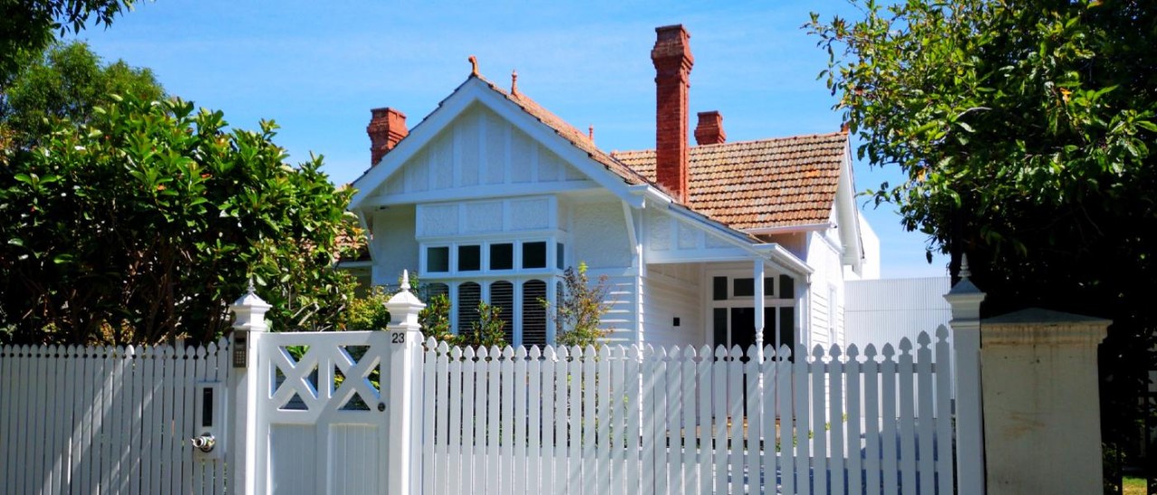 pretty Melbourne single-storey house with a chimney and white fence