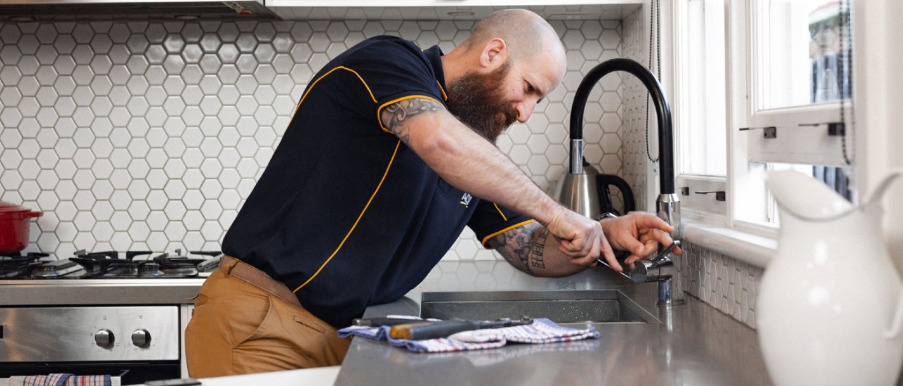 RACV plumber working on kitchen tap