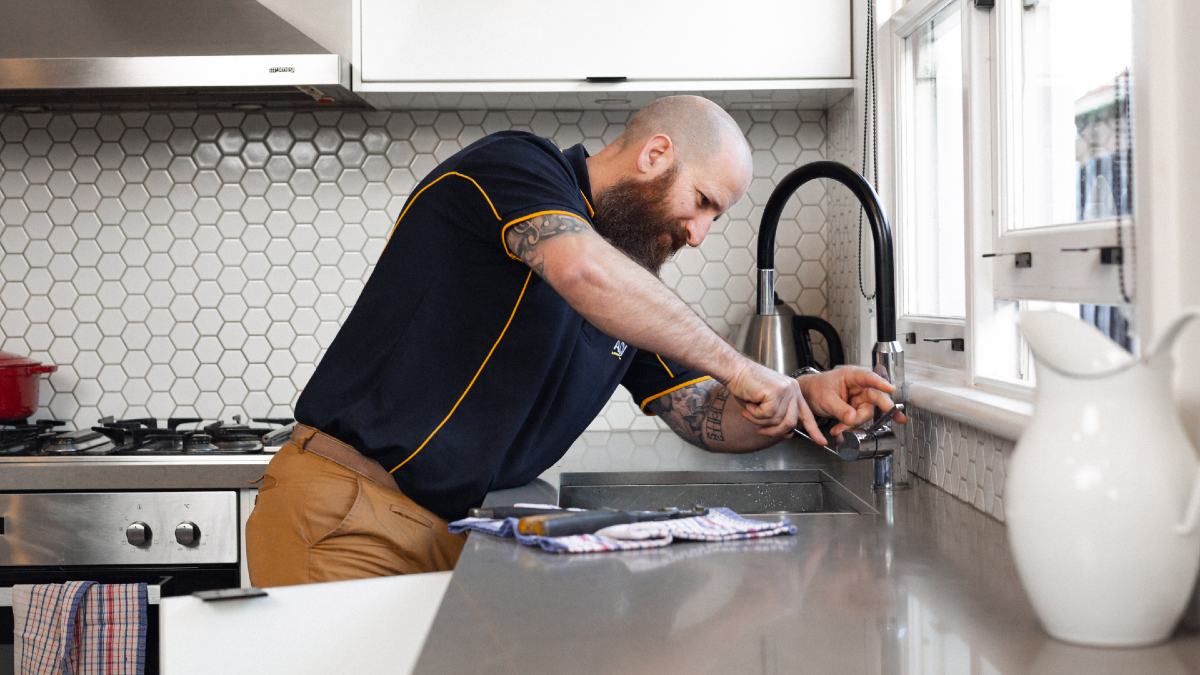 RACV plumber working on kitchen tap