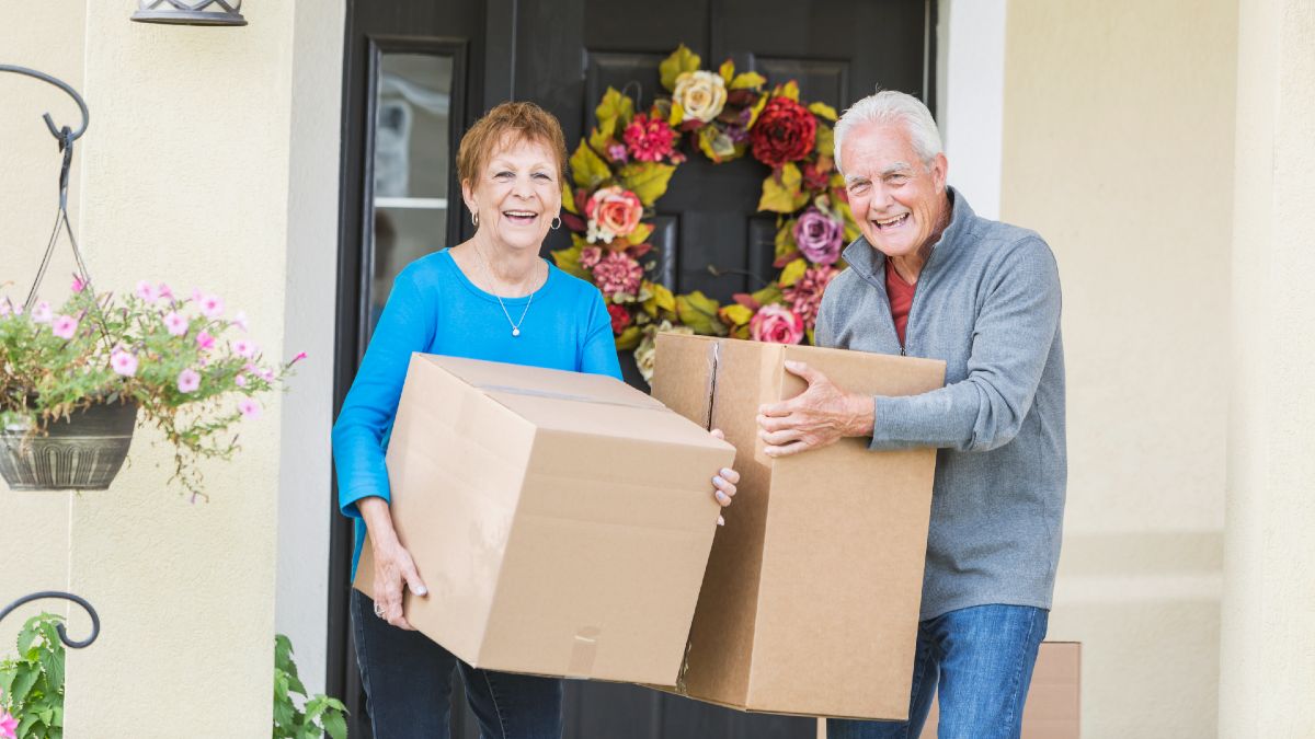 senior woman and man carrying moving boxes
