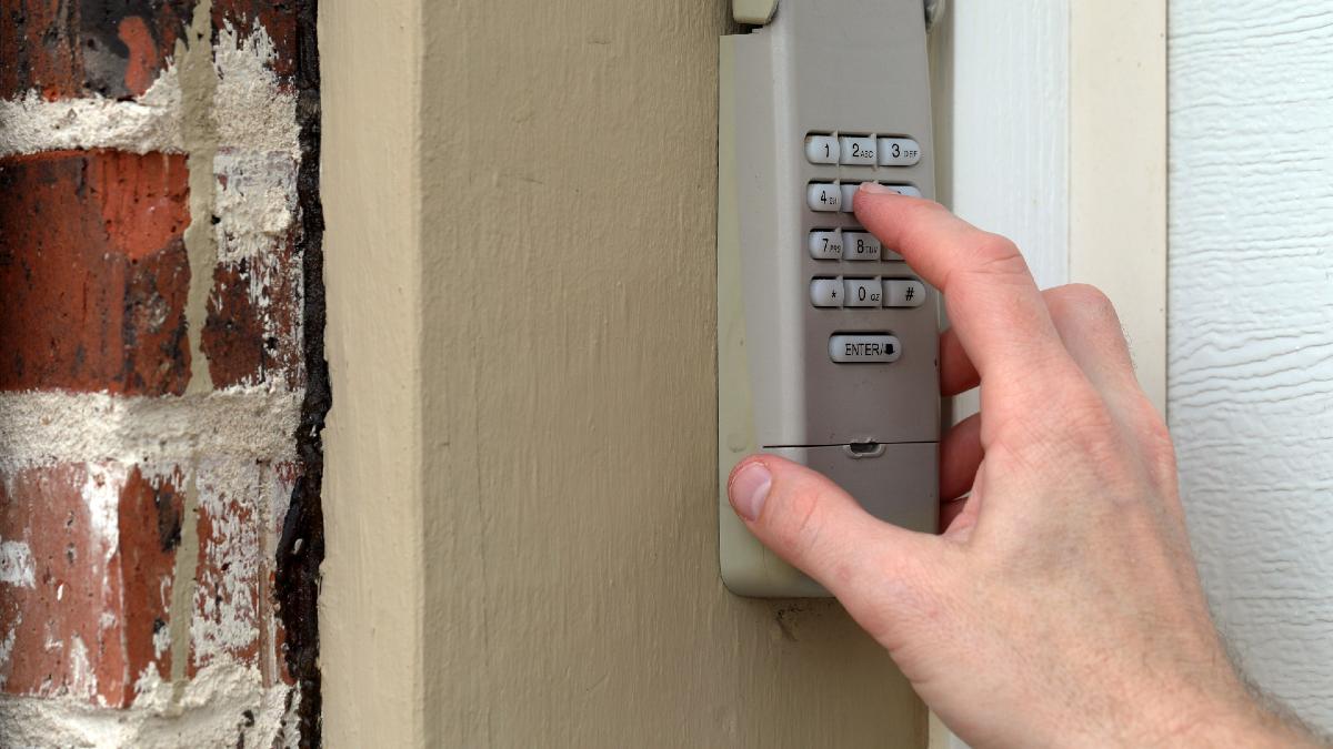 man unlocking a keypad lock on his garage door