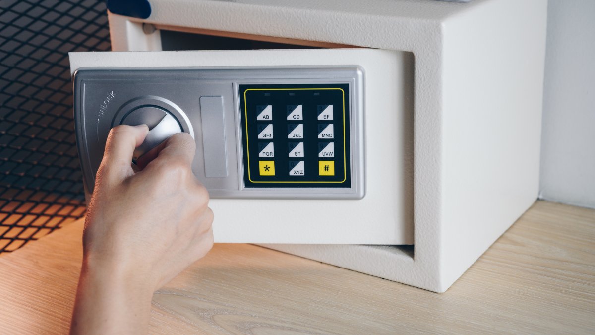 person unlocking a small portable home safe
