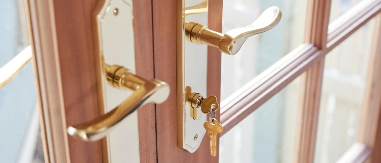 Door lock A gold front door lock with a key in it