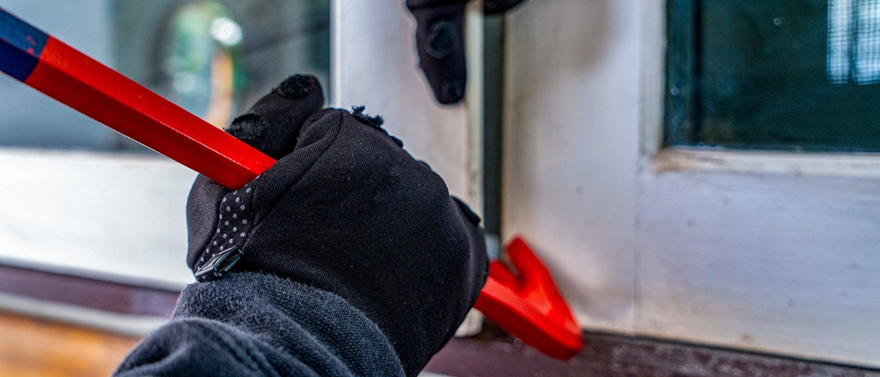 Home-burglary-window-Getty-1311907174-1400x600.jpg Close-up of burglar with crowbar prising window open
