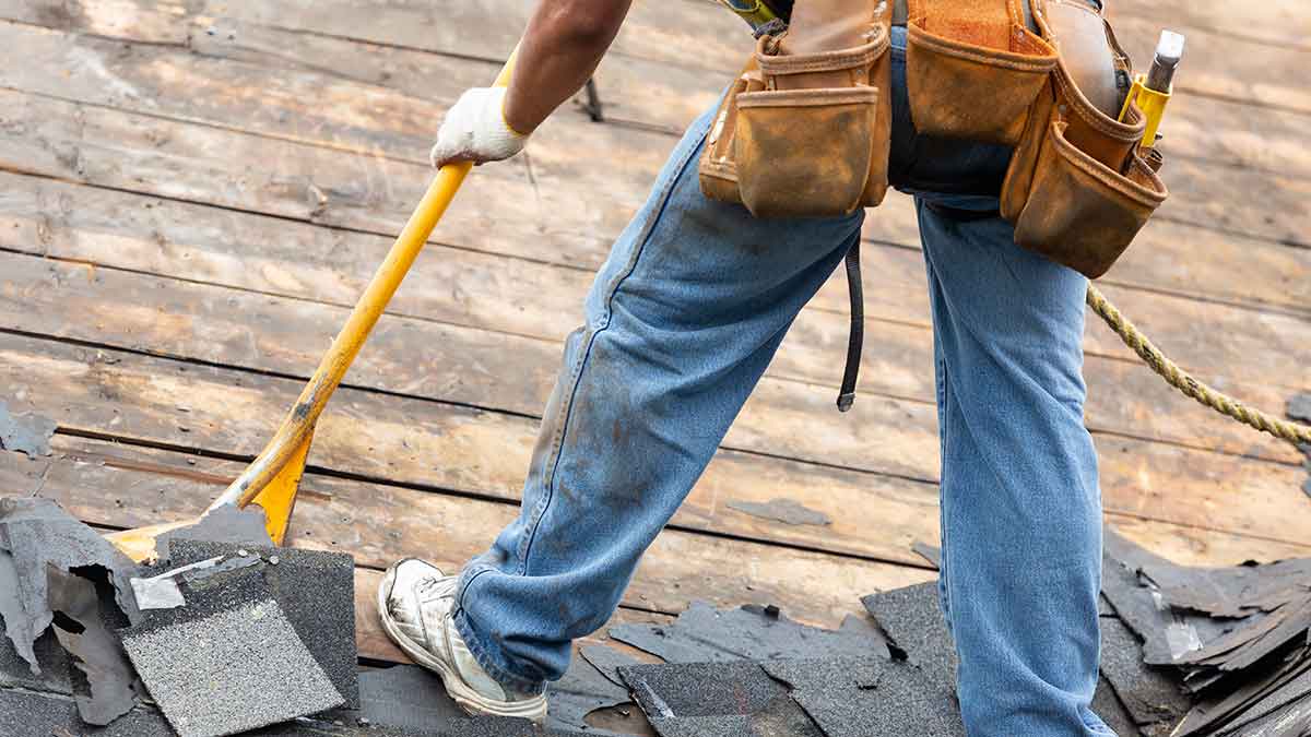Man on roof making repairs after damage