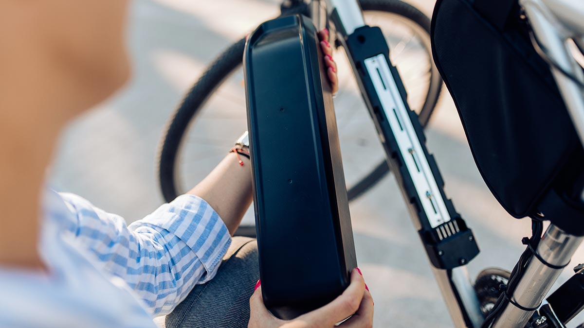 Woman removing battery from electric bike
