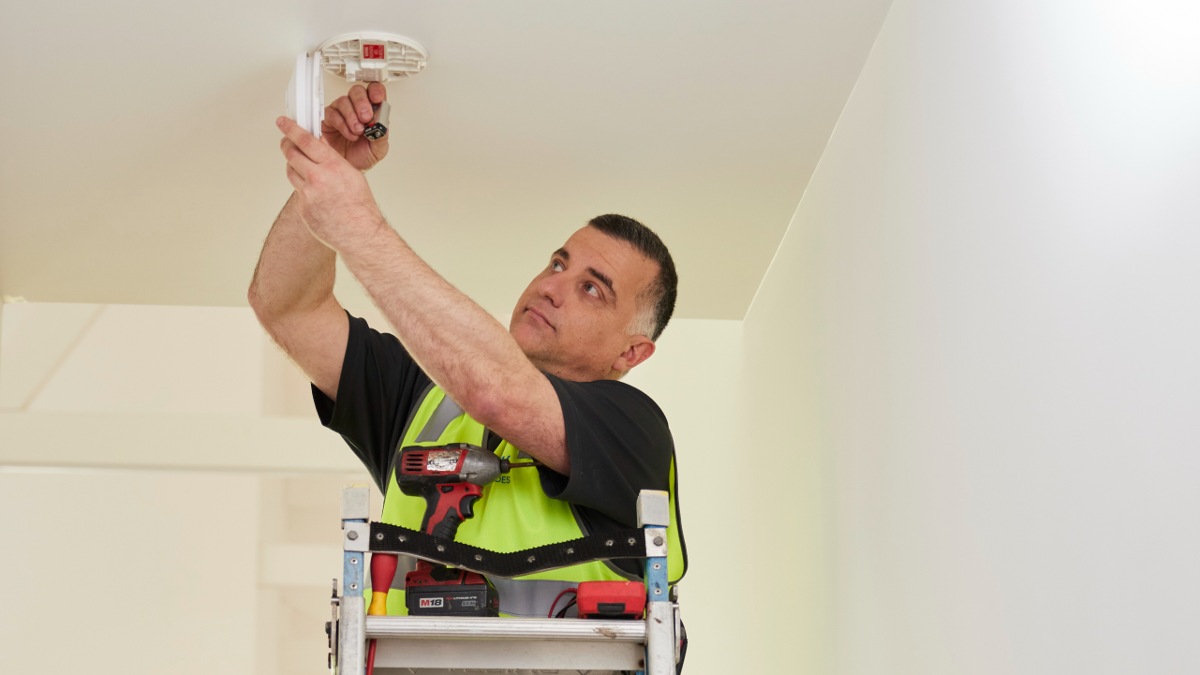 RACV electrician replacing smoke alarm battery