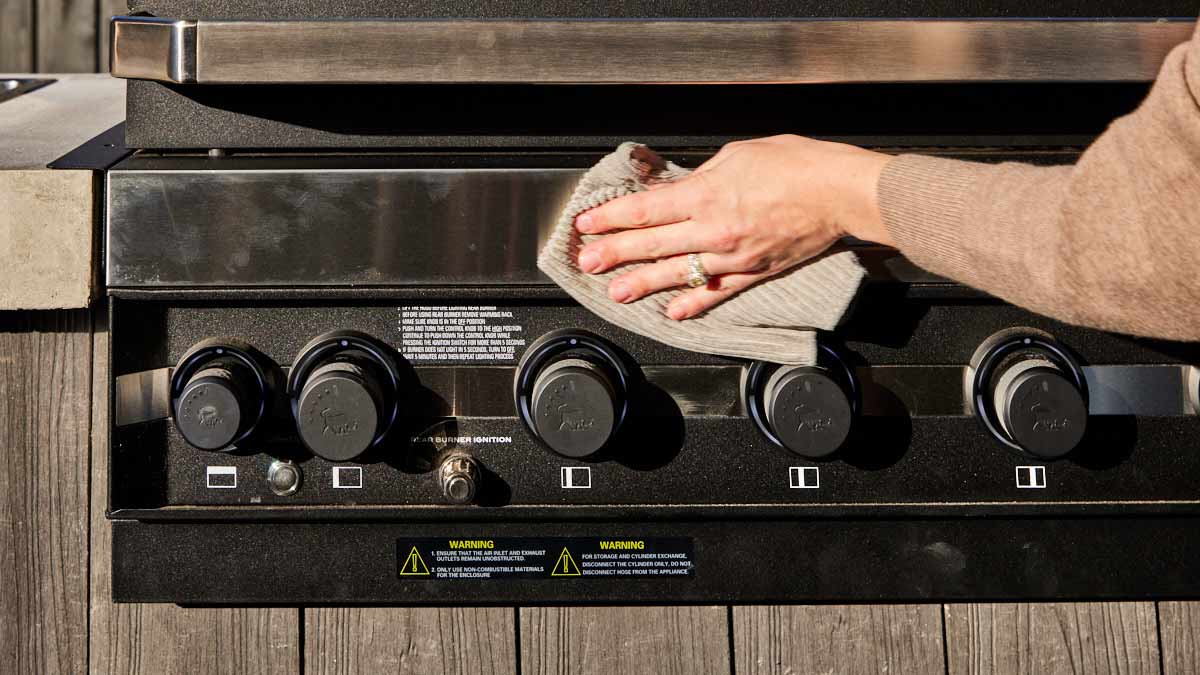 Person wiping clean a barbecue