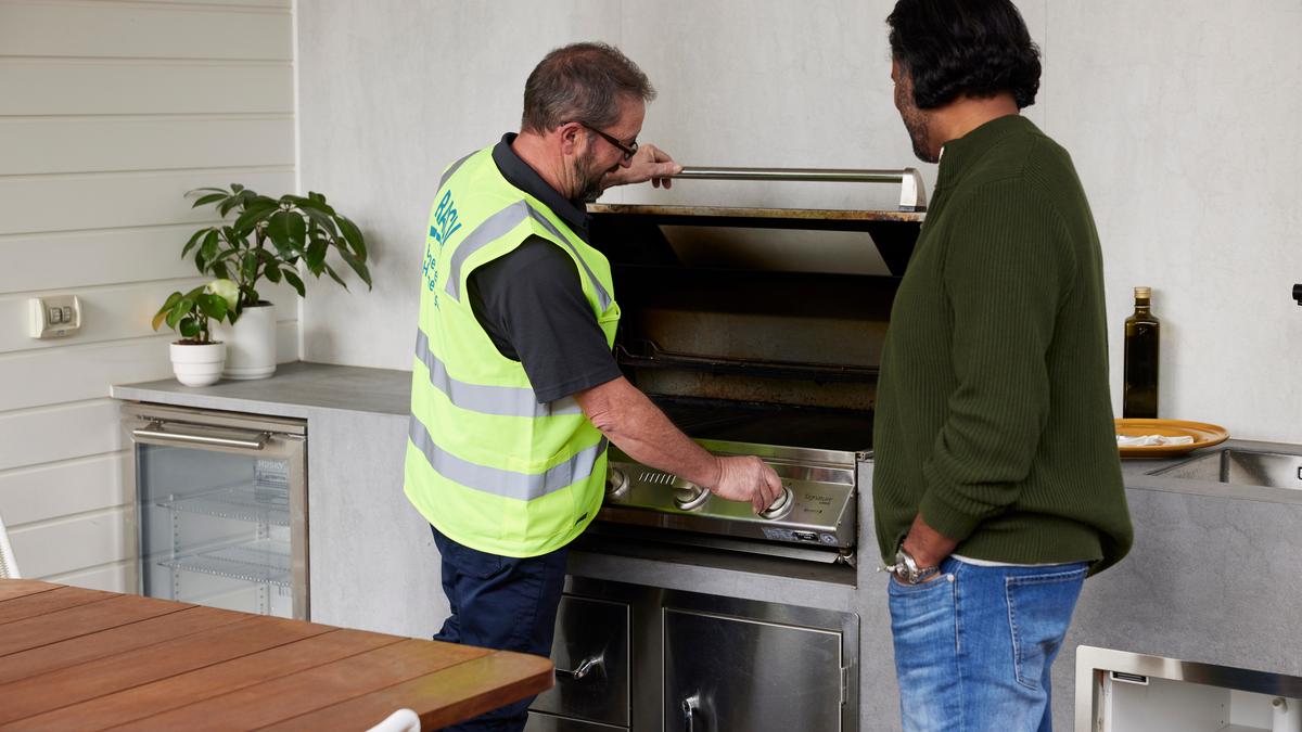 Plumber checking outdoor gas barbecue