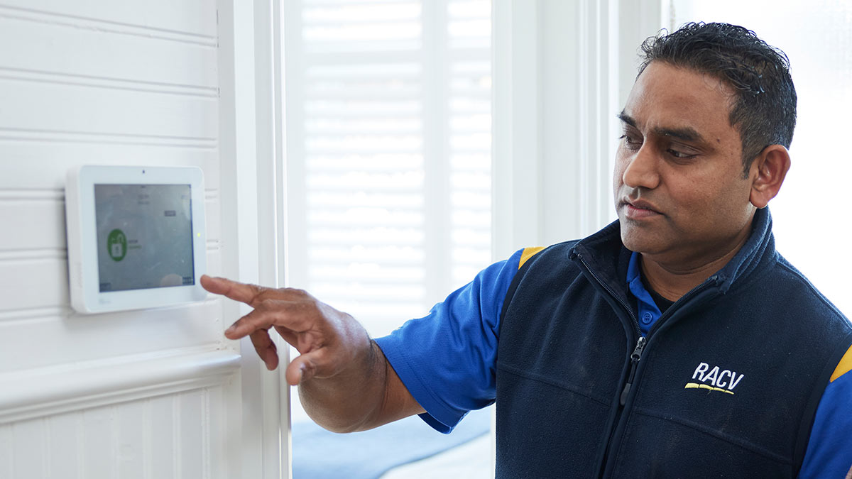RACV security technician operating alarm touch-screen in house