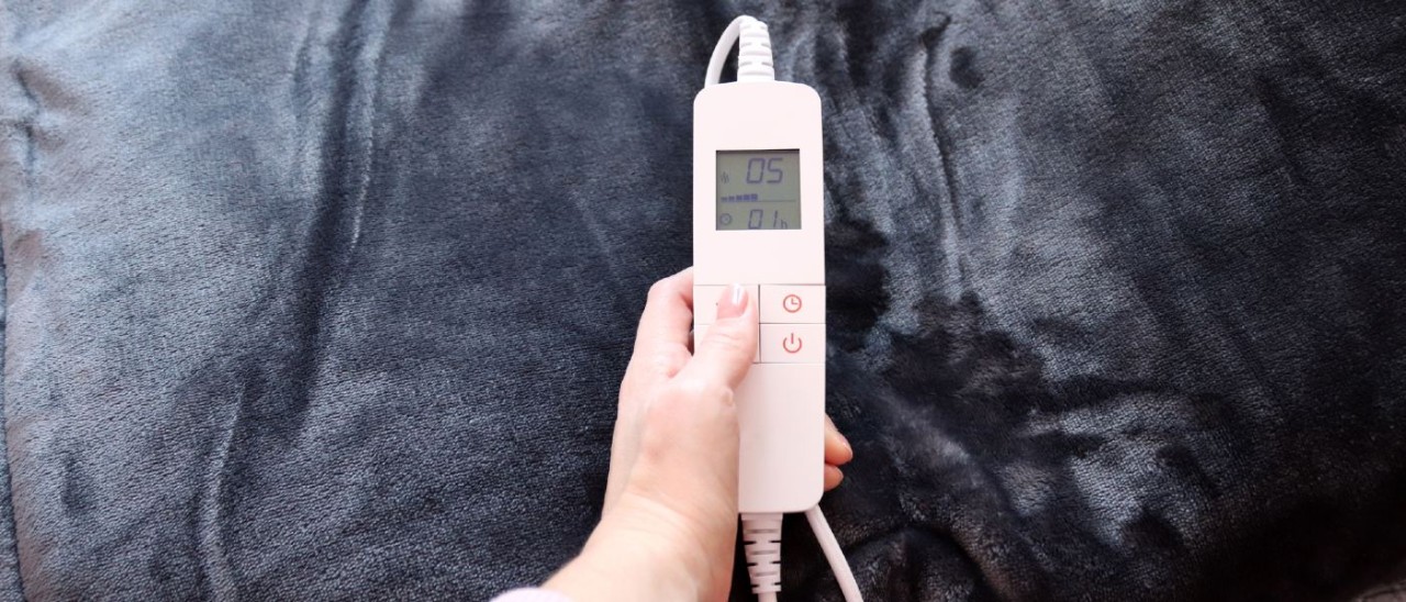 woman adjusting temperature of gray electric blanket