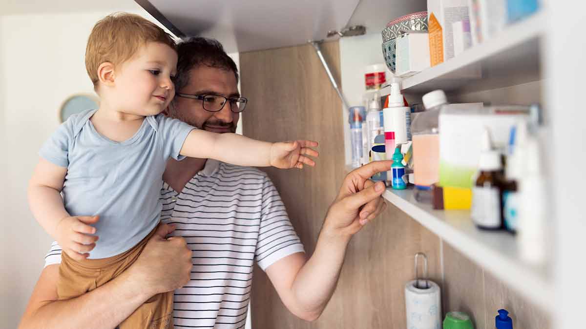 Father and son looking through medicine cabinet
