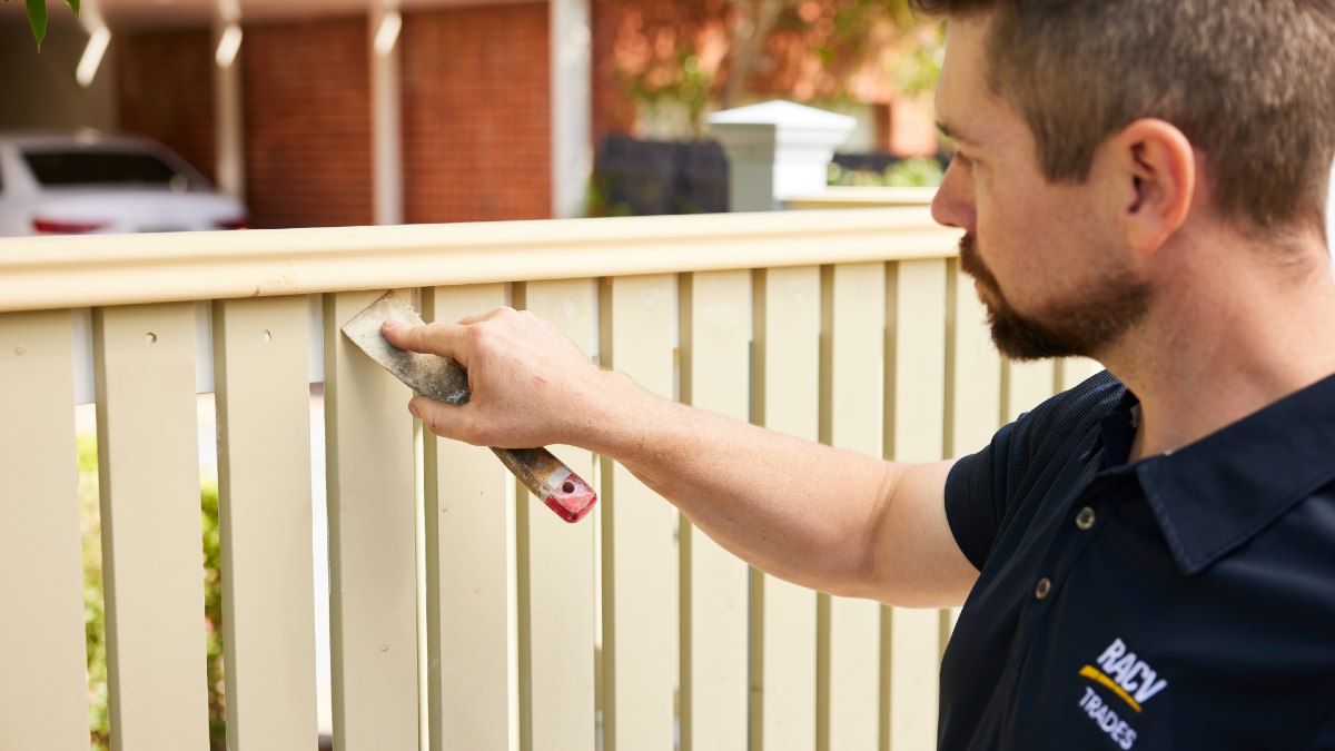 man fixing fence in front of carport
