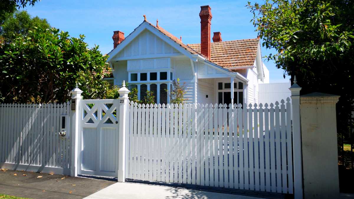 pretty Melbourne single-storey house with a chimney and white fence