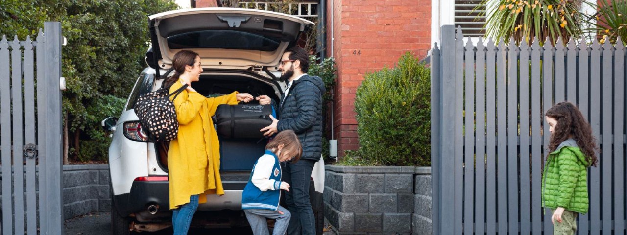 family unpacking car in driveway