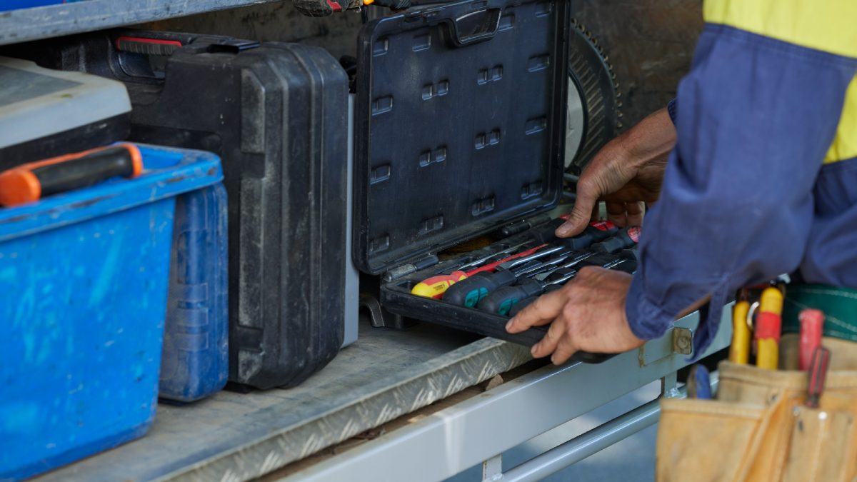 tradie examining tools in the back of his ute
