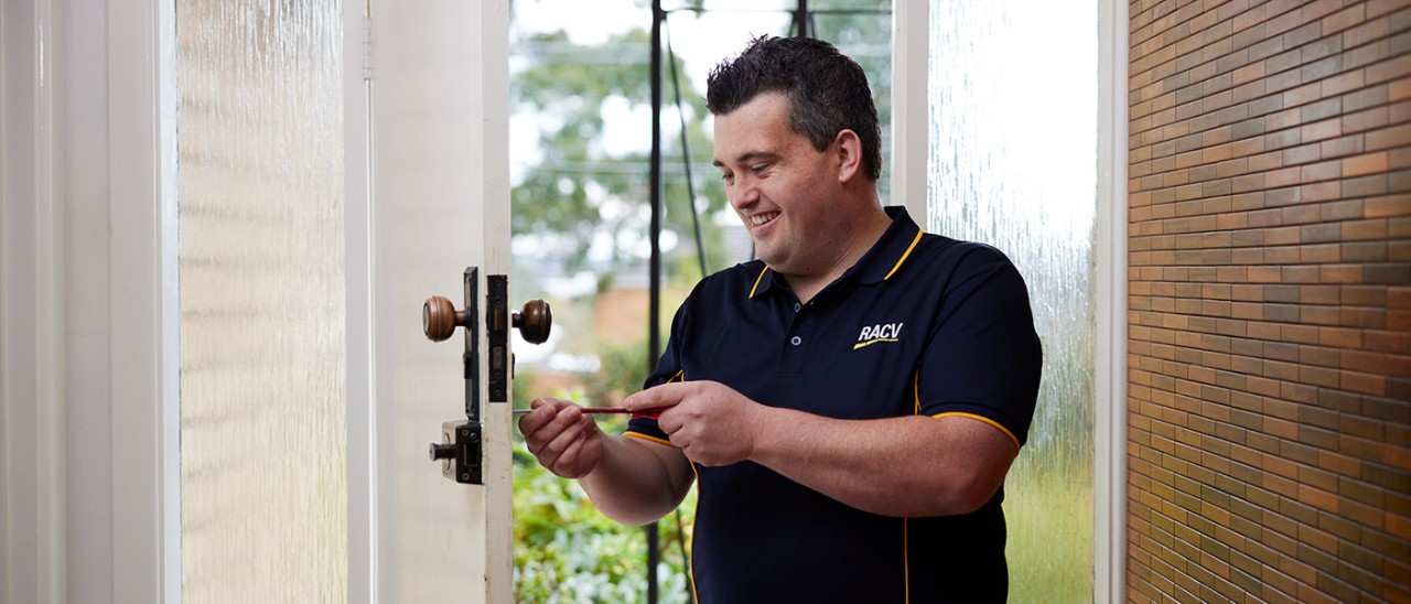 RACV Trades locksmith fixing front-door lock.