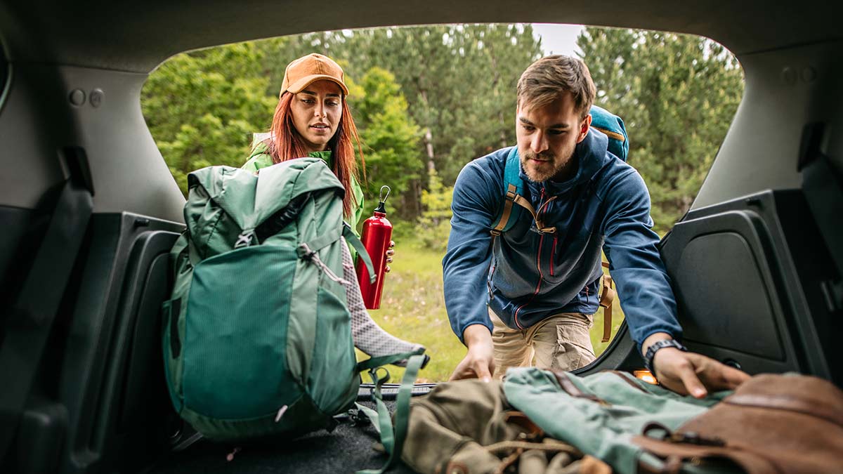woman and man packing car