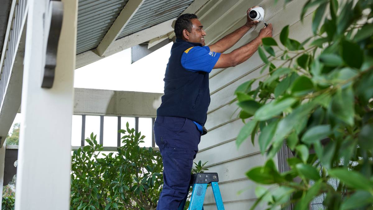 RACV tradie installing CCTV on house exterior