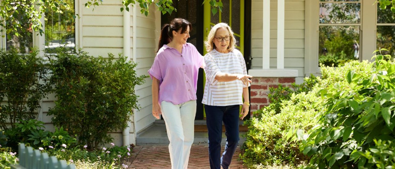 young and middle-aged woman walking out of a house together