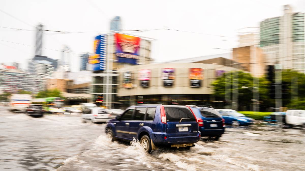 cars dangerously driving through flood water in Melbourne