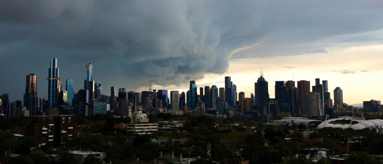 A huge, dark storm cloud looms over the Melbourne city skyline