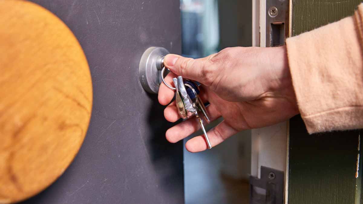 woman entering security code into apartment building entrance