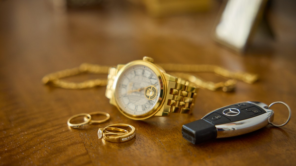 gold jewellery, watch and car key fob on bench