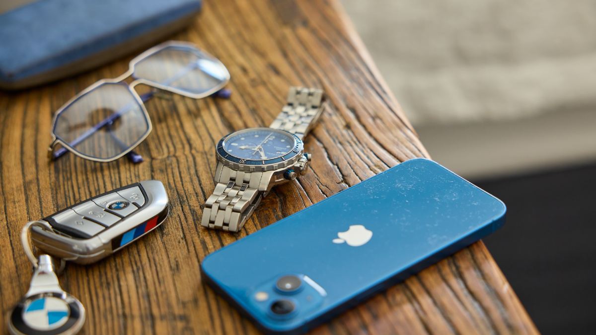 glasses, car keys, watch and smartphone on bench
