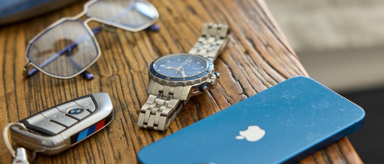 glasses, car keys, watch and smartphone on bench