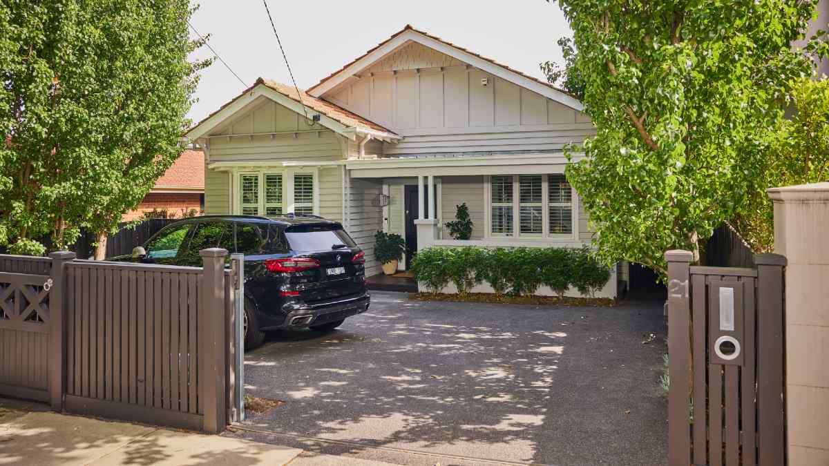 black SUV parked in front of house with open gates