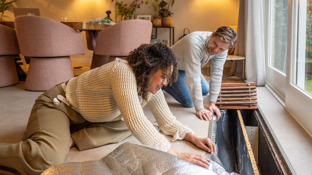 woman and man DIY installing insulation in their home