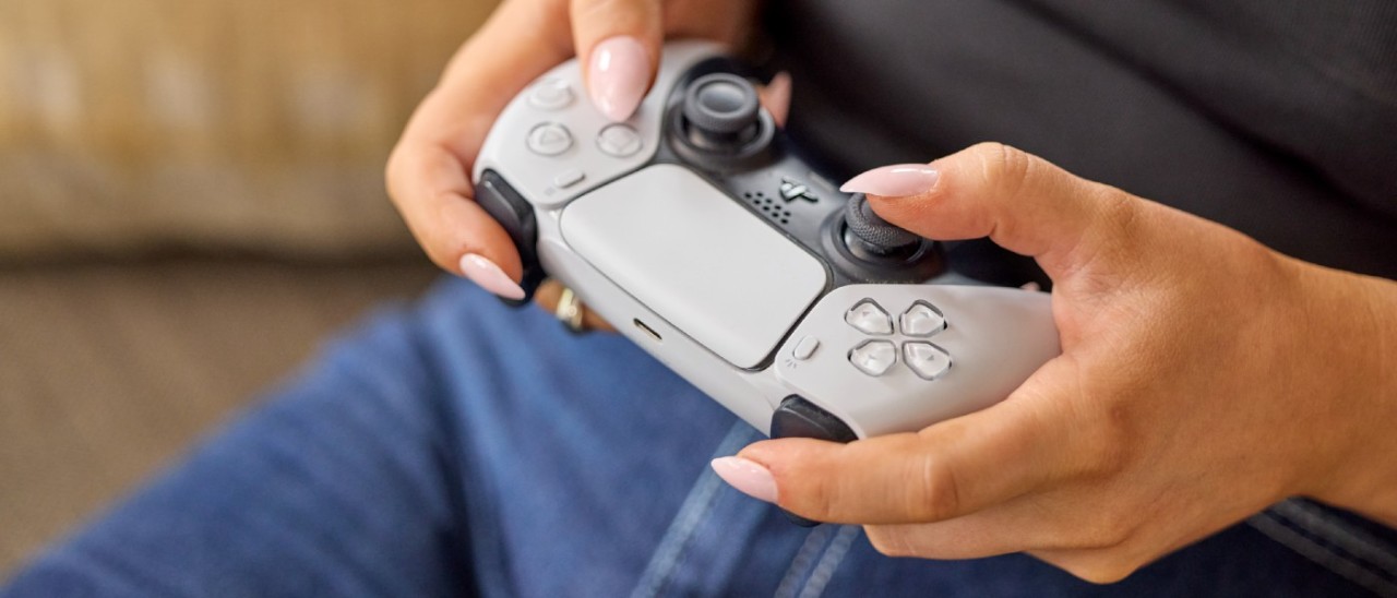 PS5 Gaming Console_RACV woman holding PS5 controller on couch