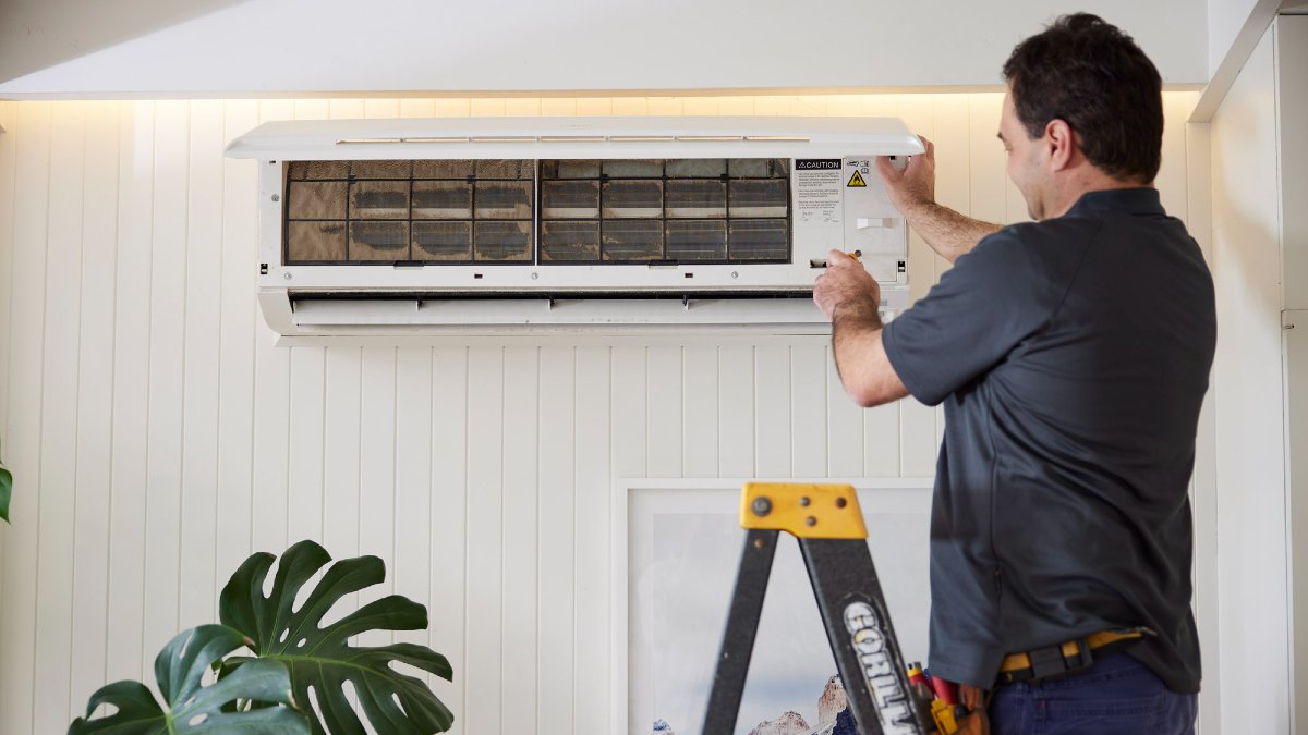 man maintaining an air conditioner