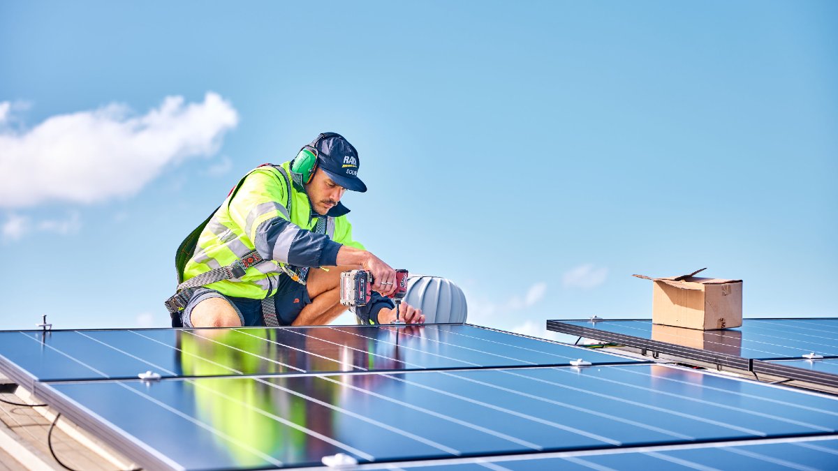 RACV Solar technician installing solar panels on roof