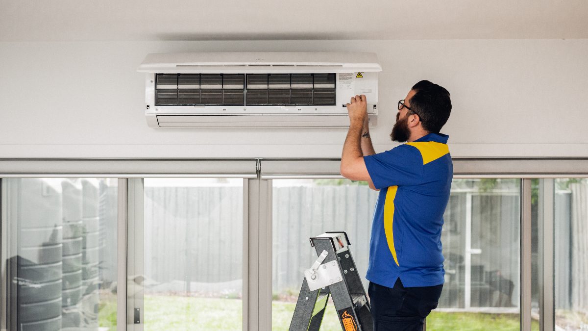 RACV Trades electrician fixing an air conditioner