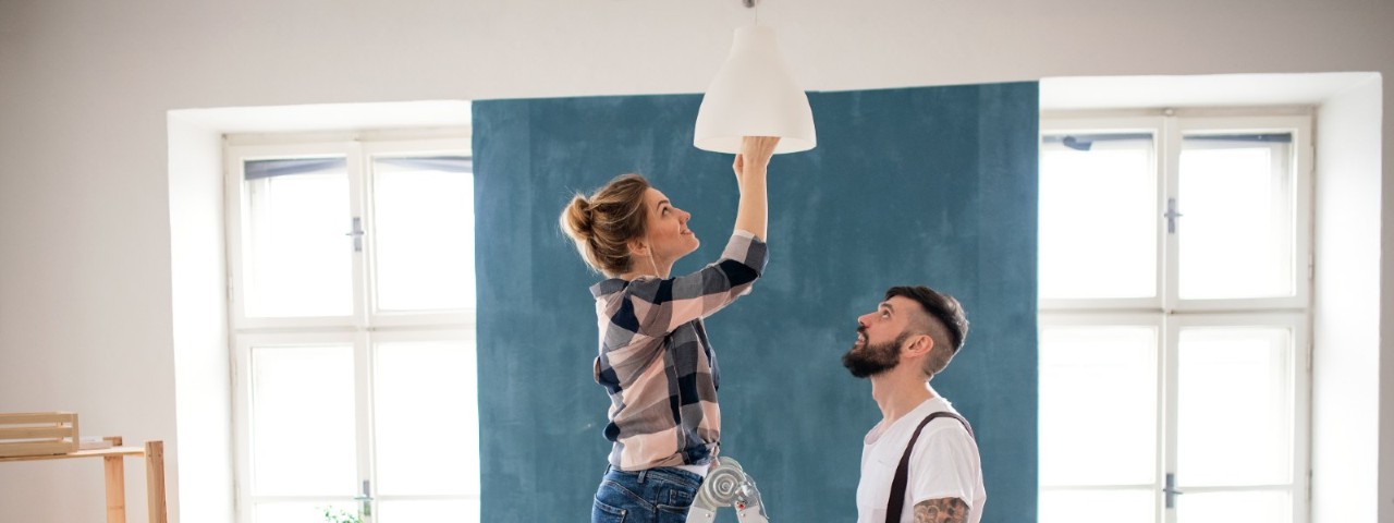 man and woman changing lightbulb