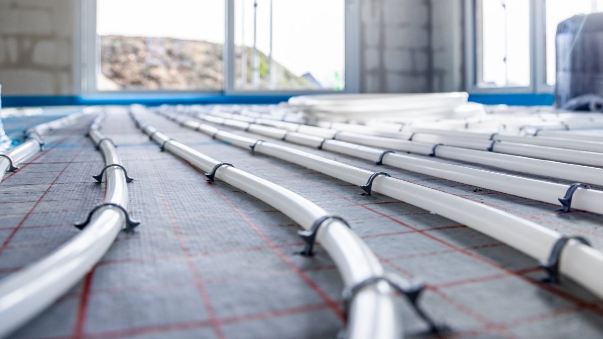 small pipes attached to the base of a house before floor is attached