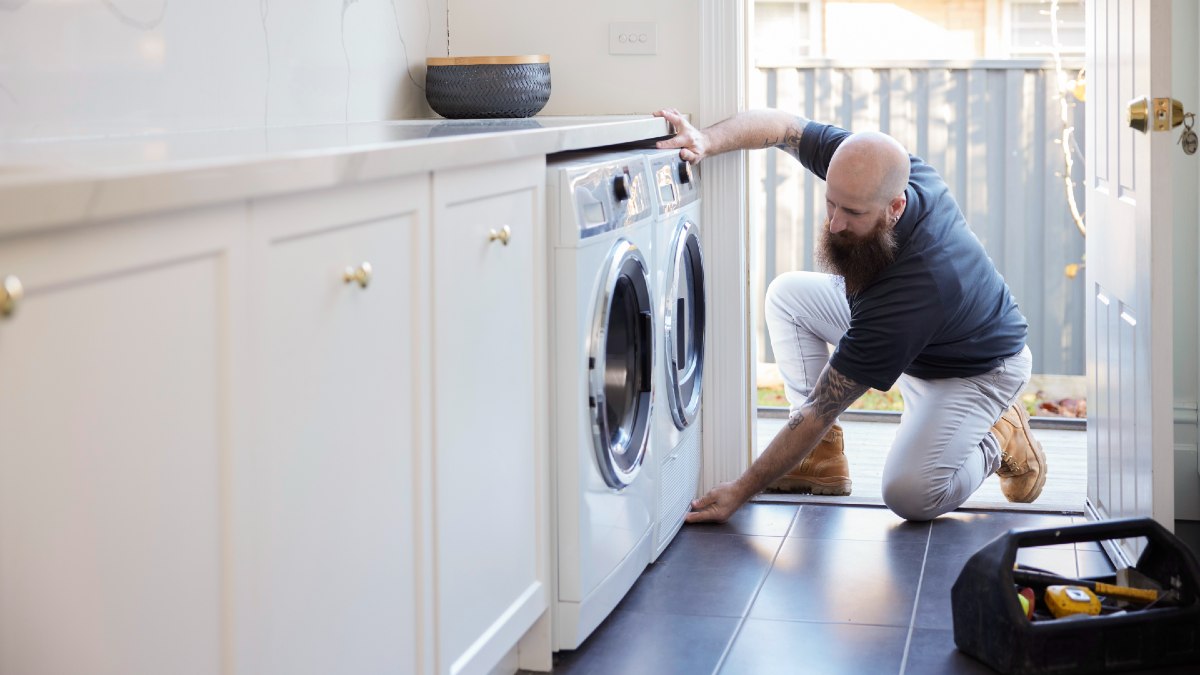 plumber tradie installing a clothes dryer