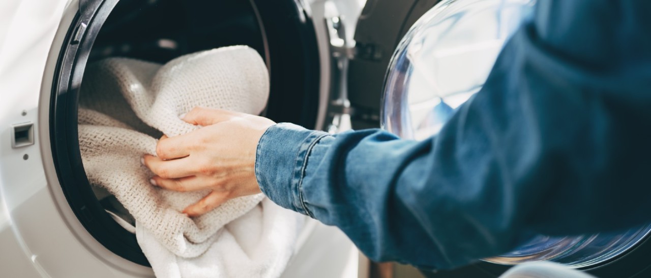 person loading clothes dryer