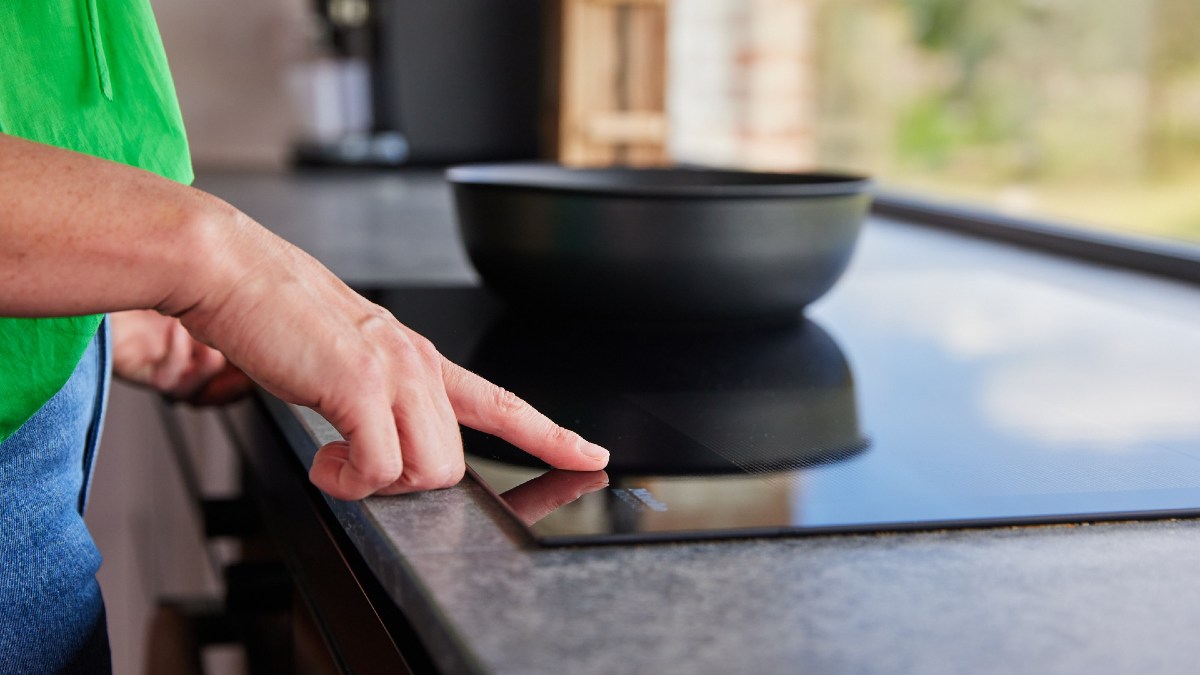 woman turning on induction cooktop