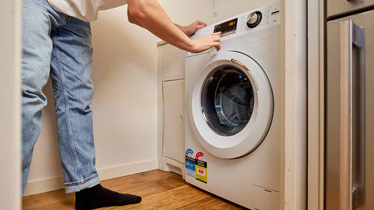 man turning washing machine load on