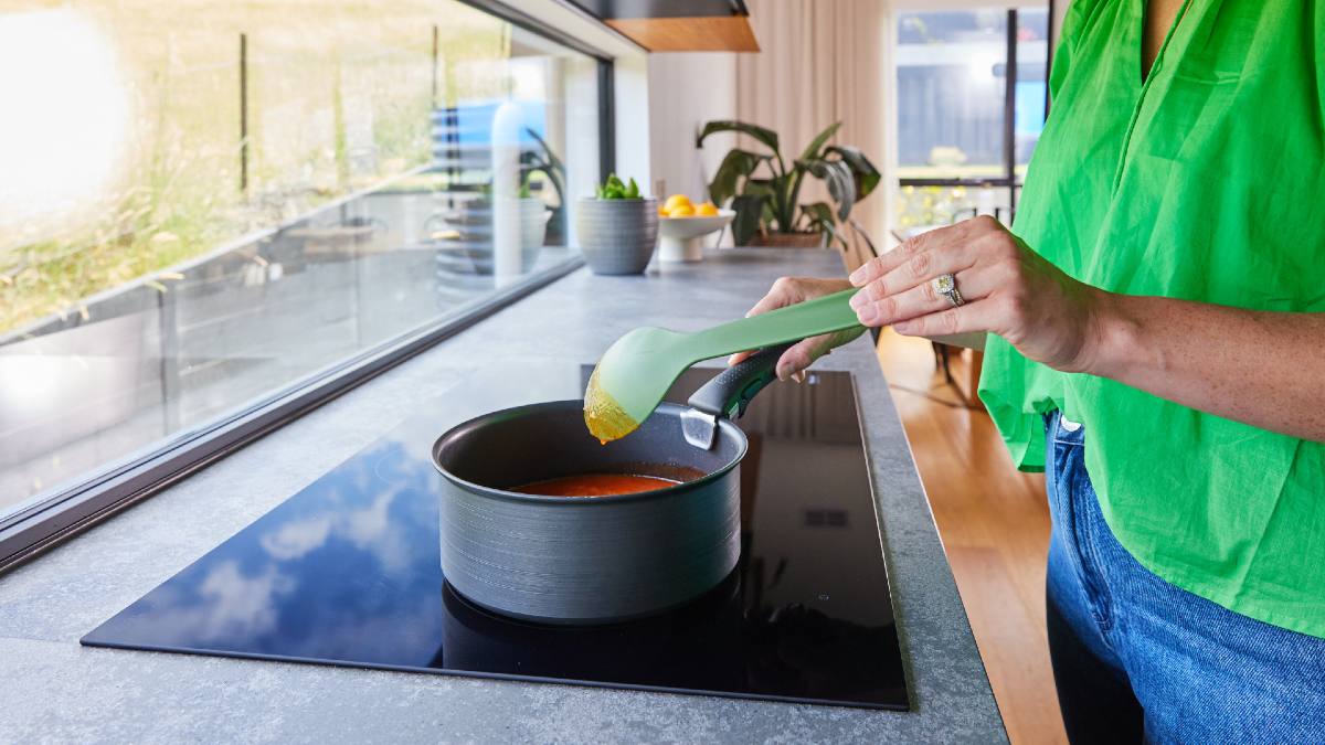 woman cooking on induction cooktop