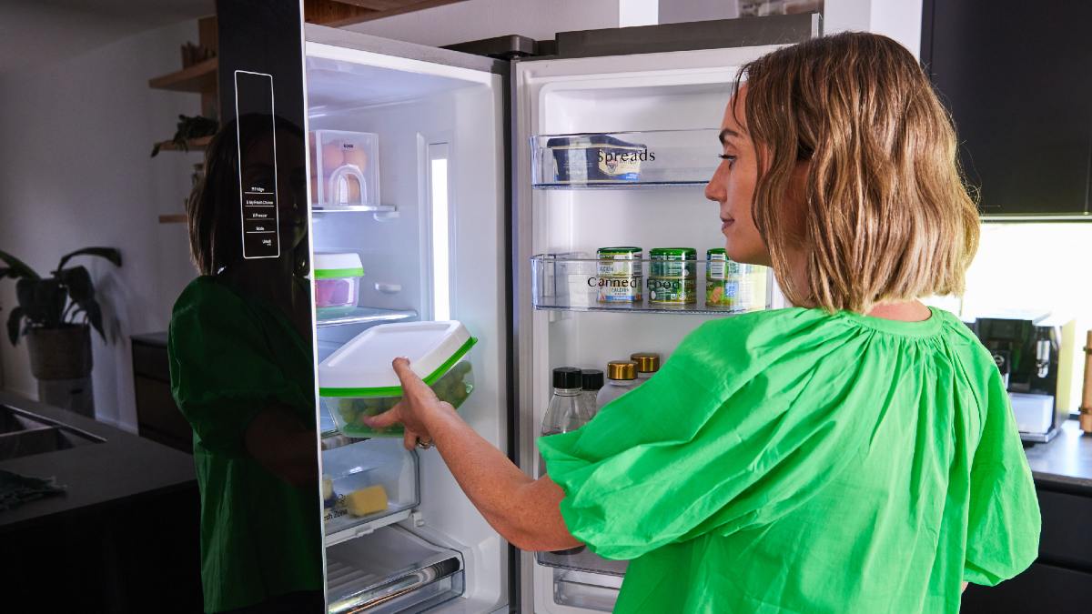 woman placing food in her fridge