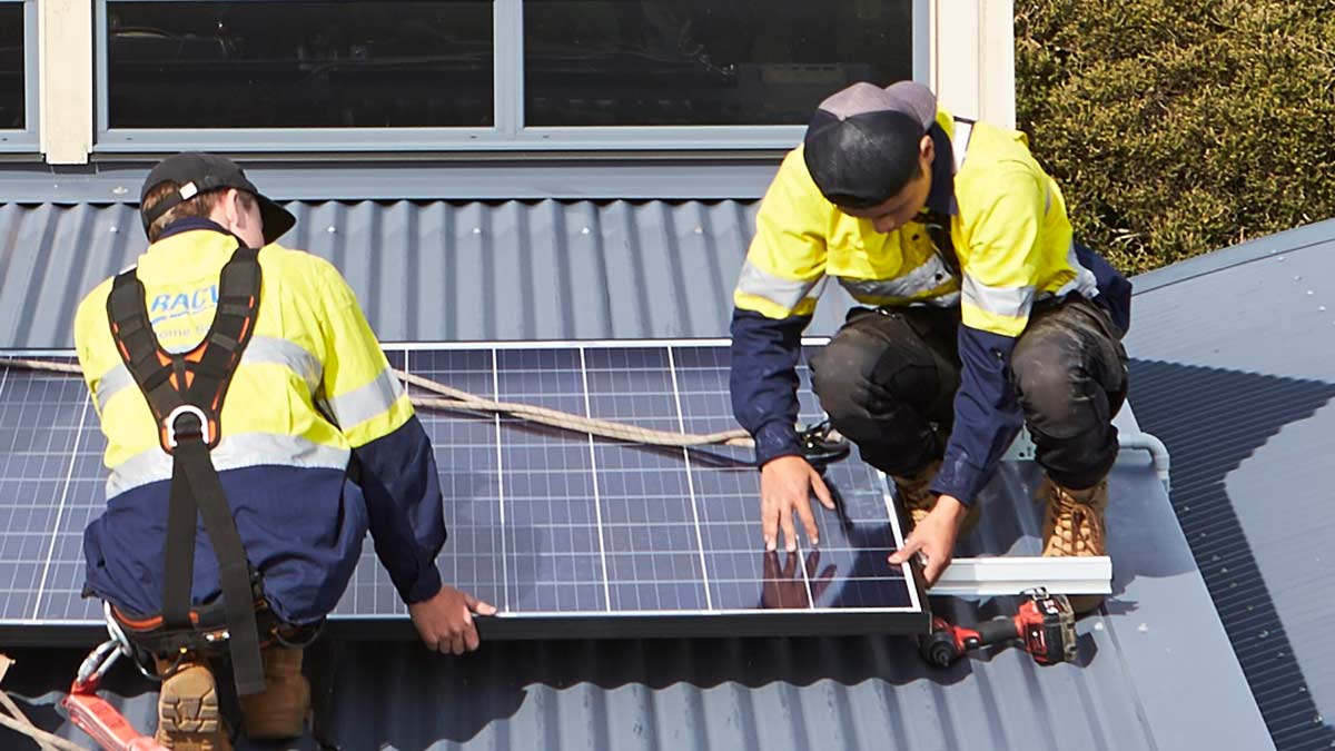 two people on roof installing solar panels