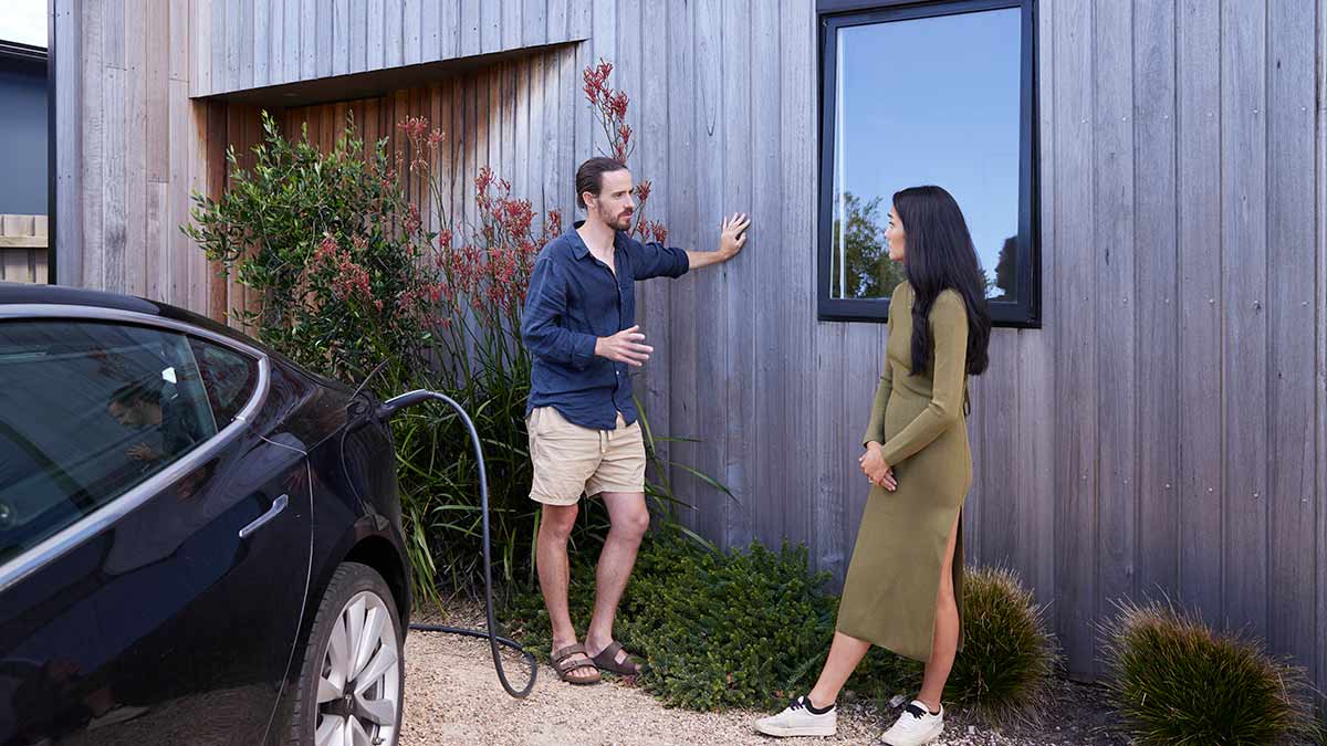 two people talking next to EV charging outside house