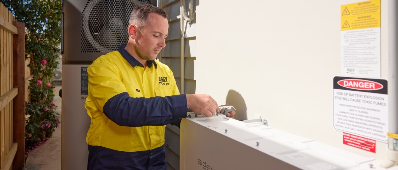 An RACV solar technician installing a solar battery