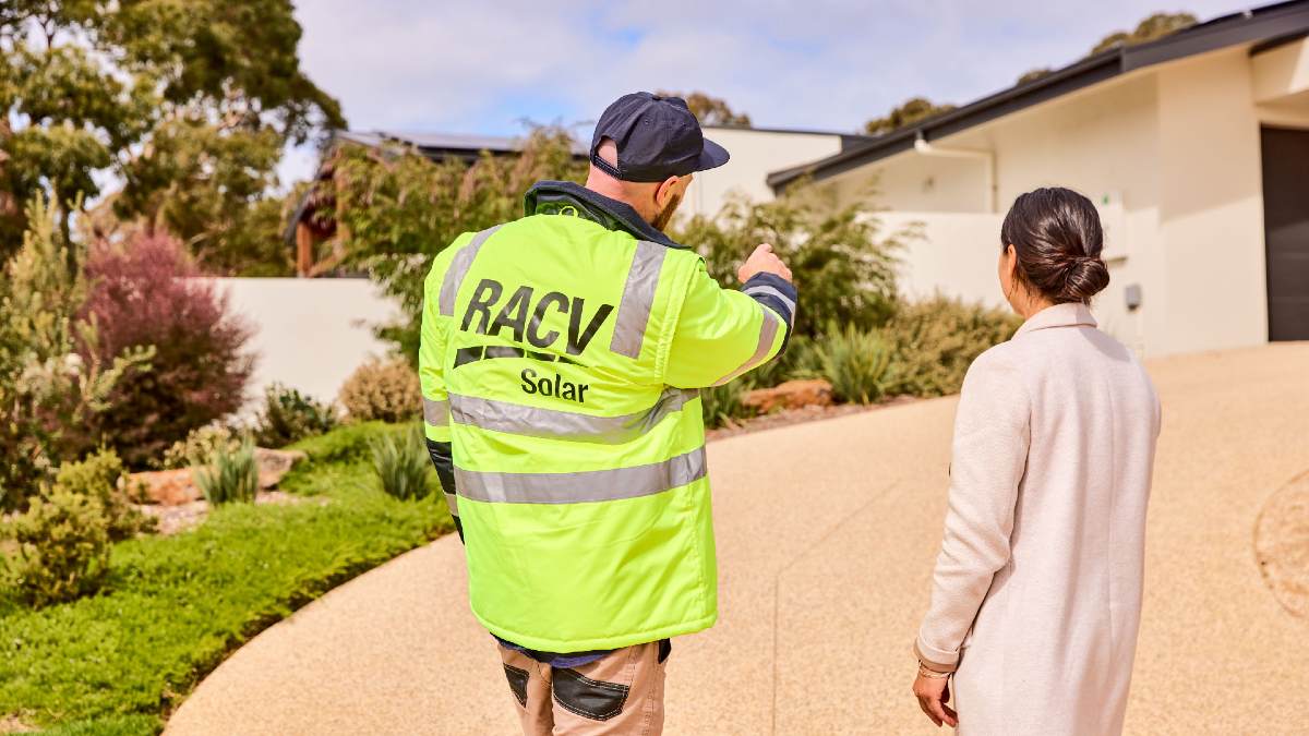 RACV Solar technician talking to homeowner while pointing at her roof