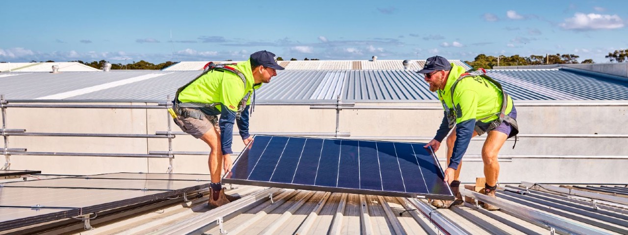 two RACV Solar technicians installing solar panels on a roof